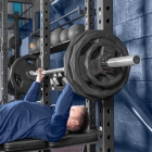 Male athlete performing chest press with Olympic weight plates