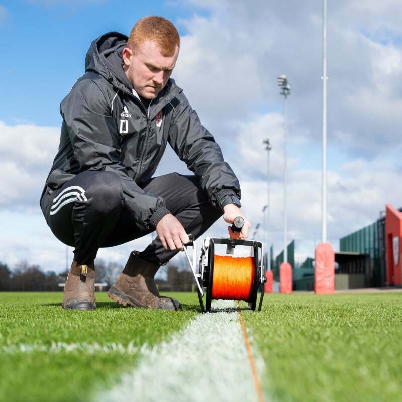 Groundskeeper adding lines to soccer field
