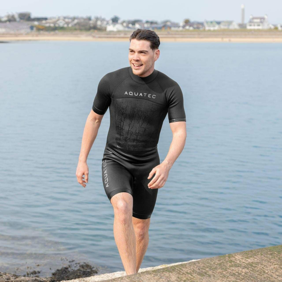 man in a wetsuit exiting the water